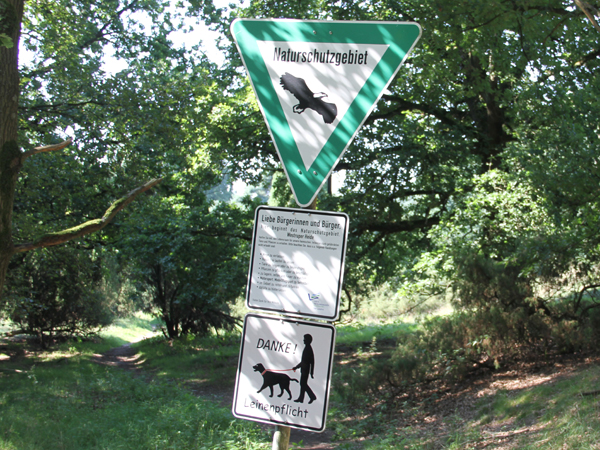 Schilder mit Hinweisen auf ein Naturschutzgebiet und Leinenpflicht für Hunde
